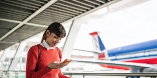 Traveler young woman using her mobile phone at an airport.
