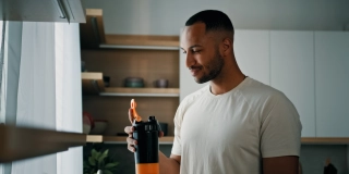 African strong healthy sports man male sport athlete bodybuilder trainer guy in kitchen smile drinking liquid calcium vitamins dietary supplements clean water protein aqua with plastic fitness bottle.