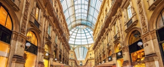 Shot of the famous Galleria Vittorio Emanuele II in Milano, Italy, the famous luxury shopping mall, showing the spectacular view of an almost golden gate to luxury.