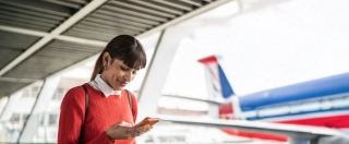 Traveler young woman using her mobile phone at an airport.