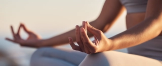 Woman, hands or lotus pose meditation on sunset beach, ocean or sea in mental health, mind training or chakra balance.