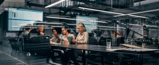Young focused serious business women and men working in a conference room working on a project presentation.