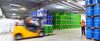 Group of workers in the logistics industry work in a warehouse with chemicals.